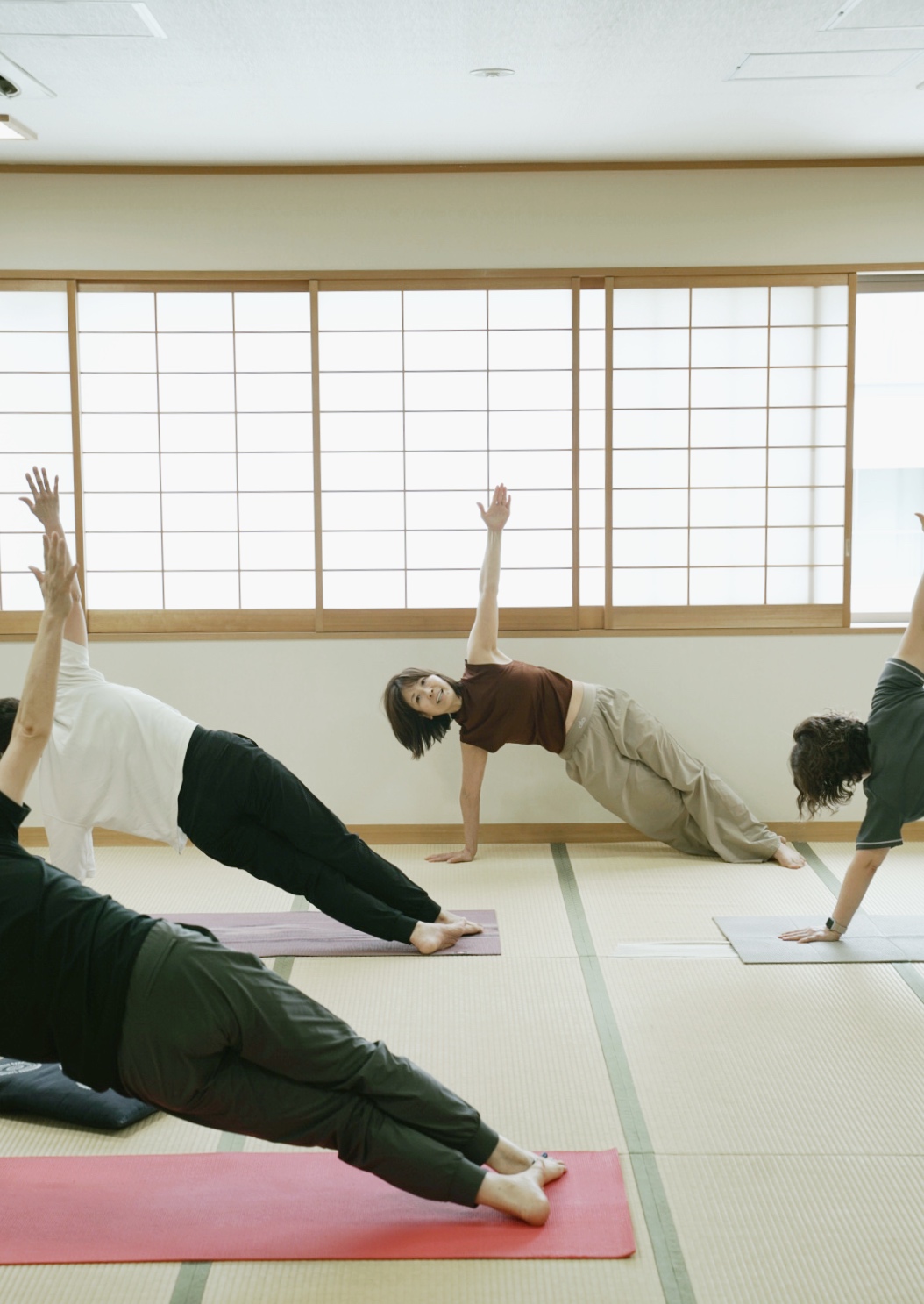 畳の和室で複数人が参加するヨガレッスン